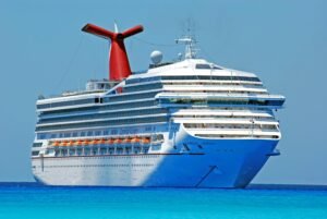 Royal Carribean A large cruise ship gliding through clear blue ocean waters on a sunny day.