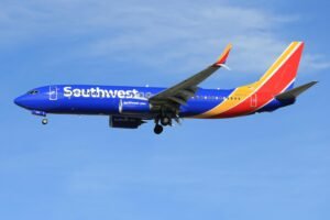 Southwest Airline. Airplane flying against a clear blue sky, showcasing its colorful livery.